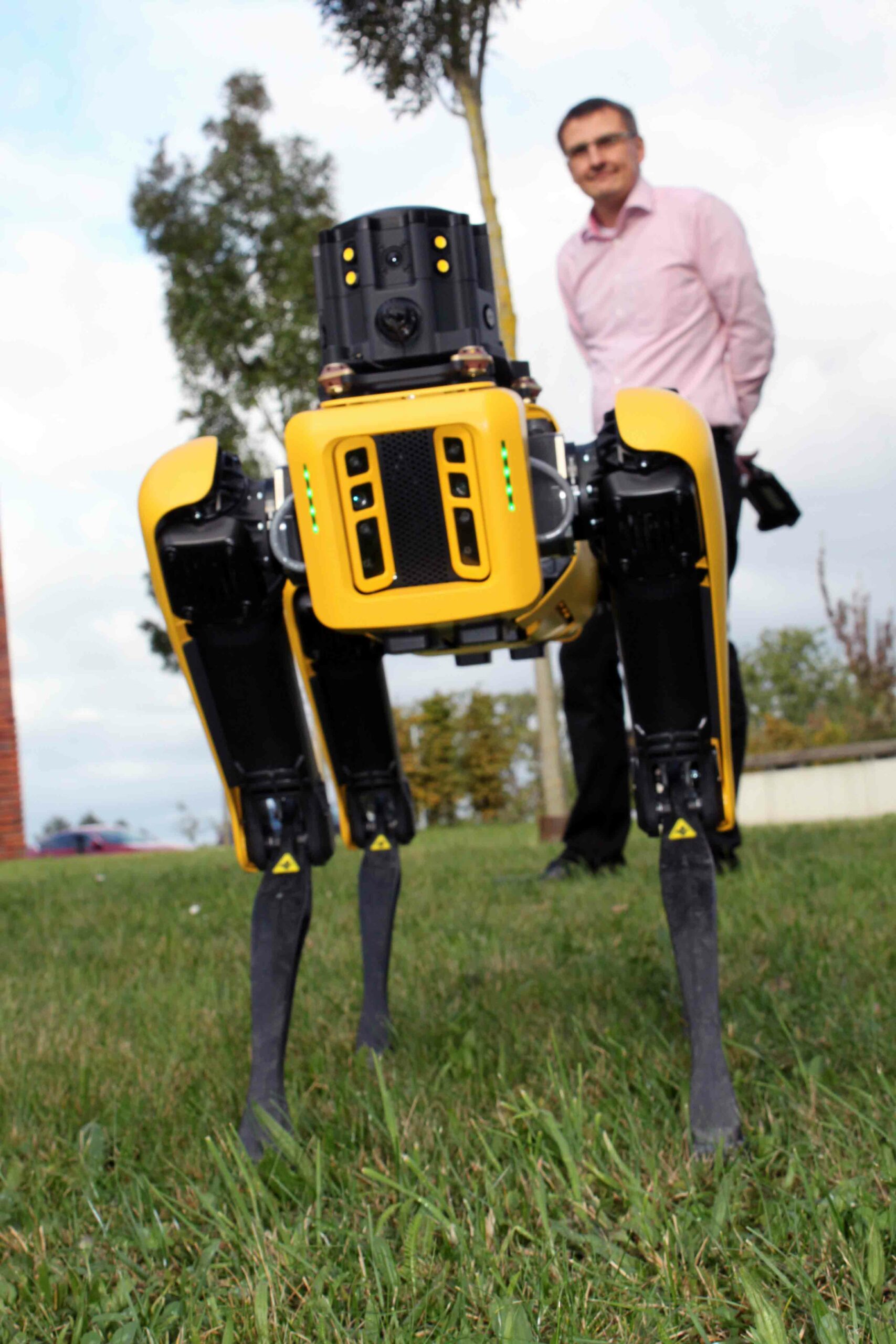 Professor Norbert Schmitz (Hintergrund) führt Roboterhund „Spot“ auf dem Pforzheimer Campus aus. Foto: Sophia Zundel / Hochschule Pforzheim